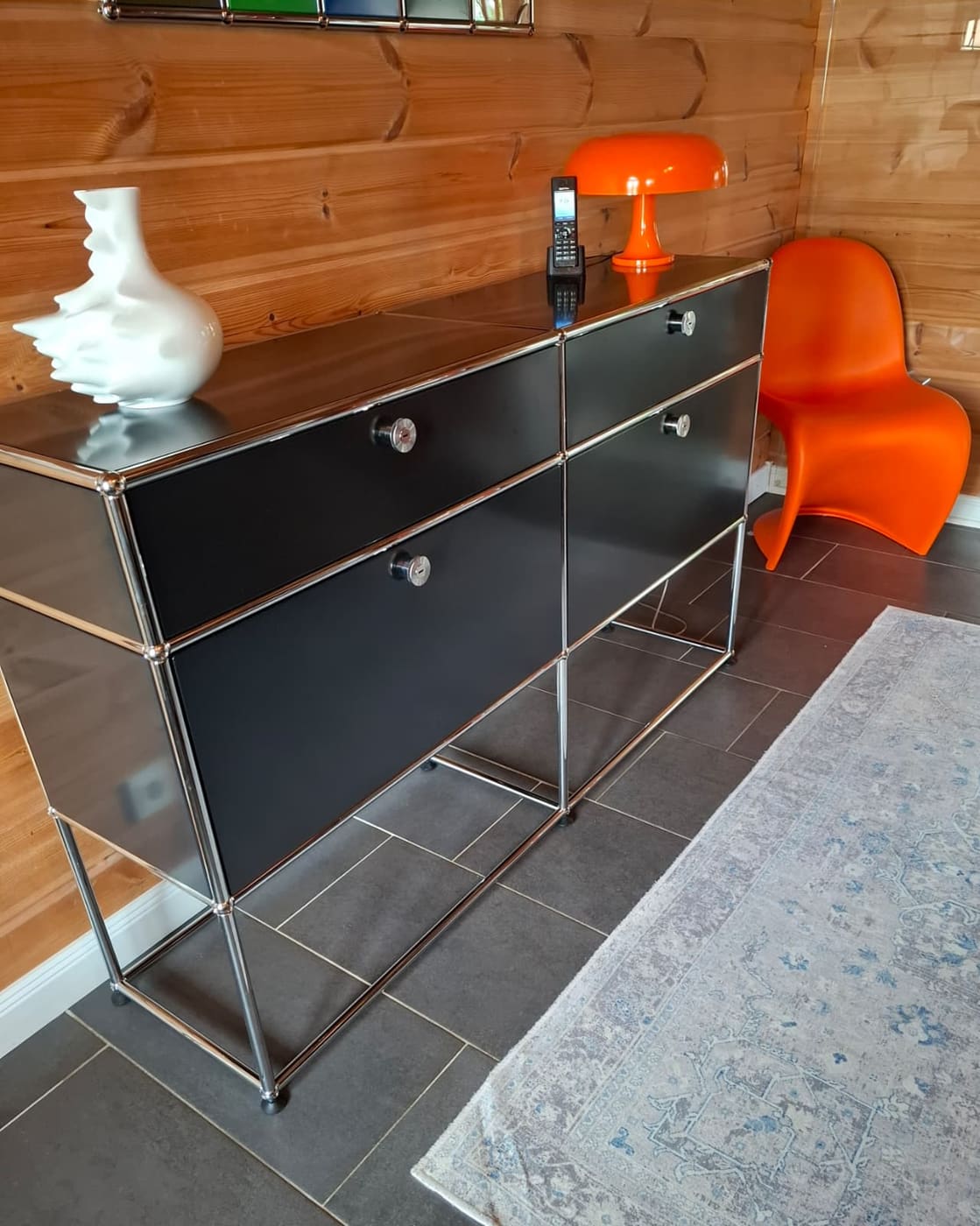Schwarzes Sideboard im Wohnzimmer mit Panton-Stuhl
